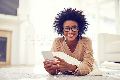 Buy stock photo Black woman, portrait and afro with phone on living room floor for social media, blog or reading news at home. African, female person or freelancer on mobile smartphone for communication at house