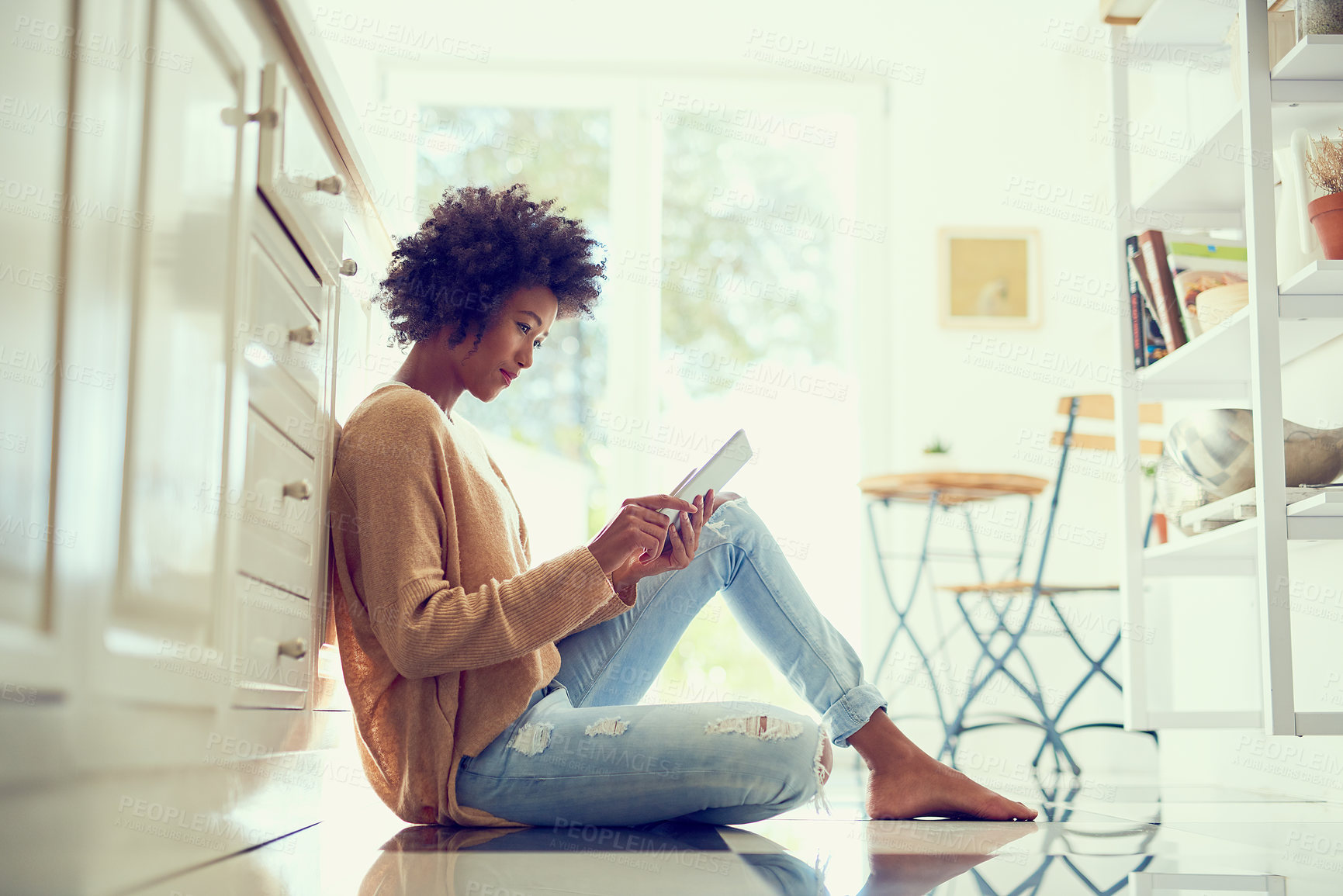 Buy stock photo Shot of a young woman using a digital tablet at home