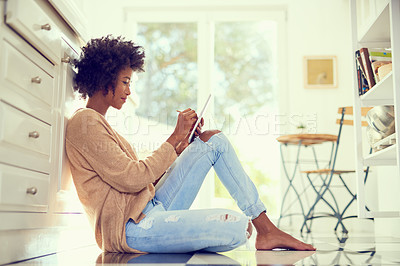 Buy stock photo Shot of a young woman using a digital tablet at home