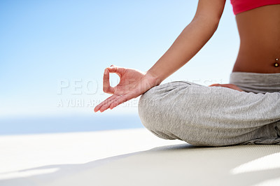 Buy stock photo Shot of a young woman meditating while doing yoga outside on a sunny day