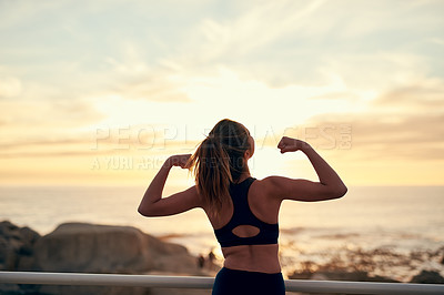 Buy stock photo Shot of a young sporty woman flexing after her workout