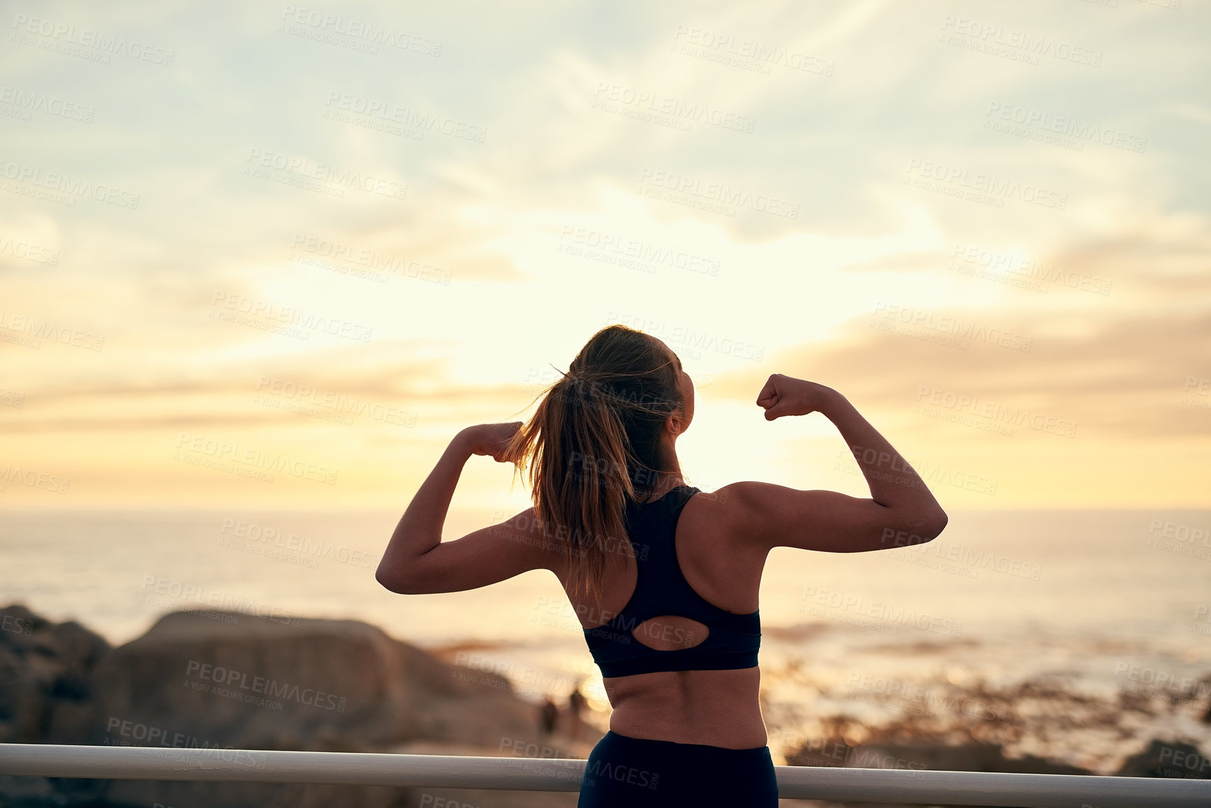 Buy stock photo Shot of a young sporty woman flexing after her workout