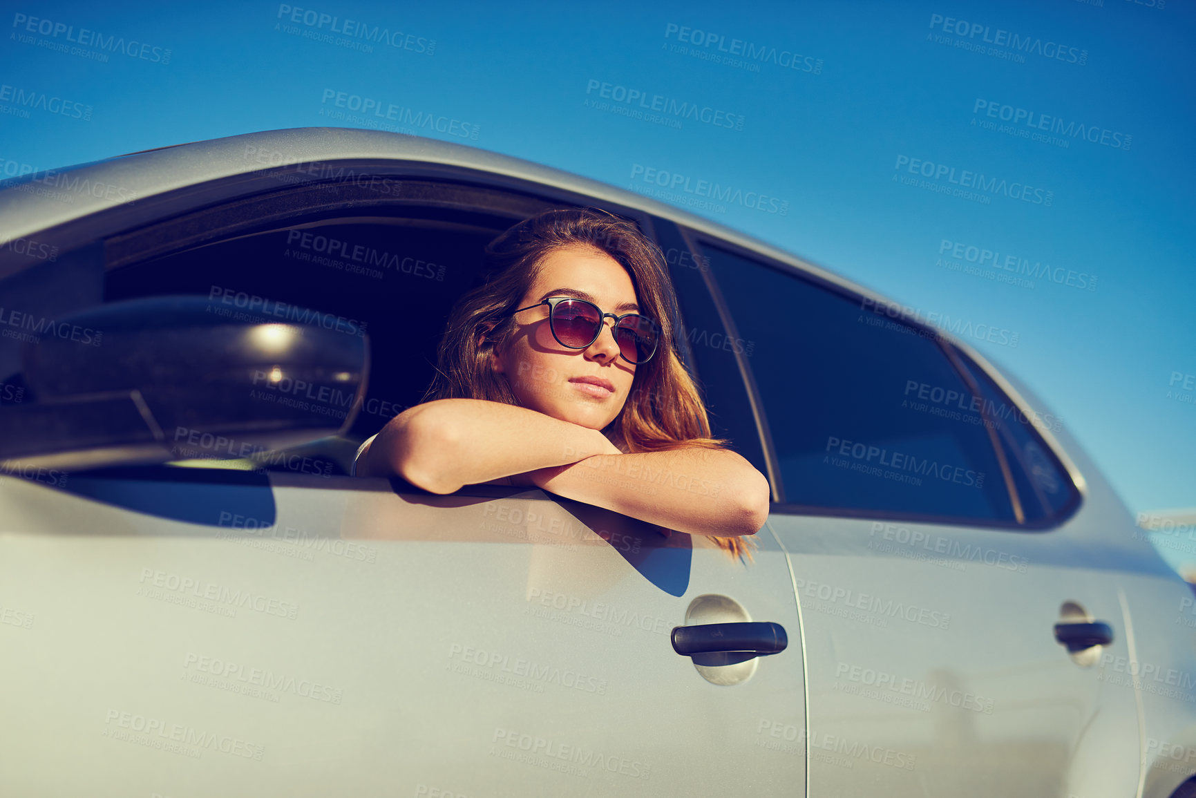 Buy stock photo Shot of a young woman looking at the view while sitting in her car