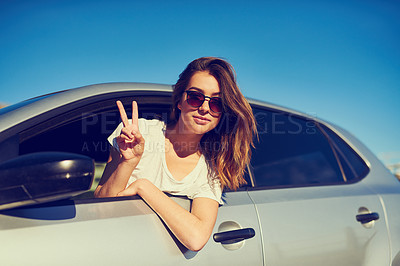Buy stock photo Portrait of a young woman giving you the peace sign while sitting in her car