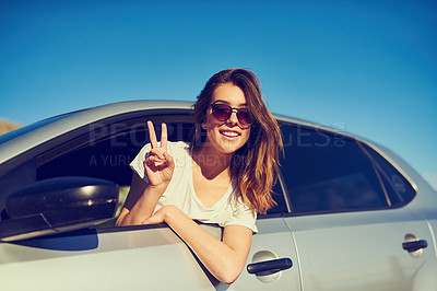 Buy stock photo Portrait of a young woman giving you the peace sign while sitting in her car