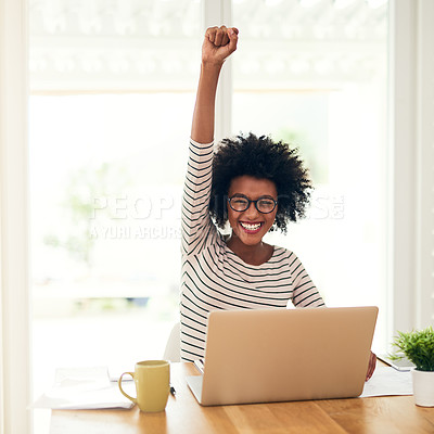 Buy stock photo Portrait of a young woman doing a fist pump while working on her laptop at home
