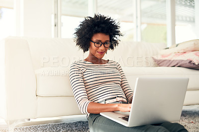 Buy stock photo Cropped shot of a young woman working on her laptop at home