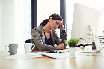 Buy stock photo Cropped shot of a young businesswoman looking bored at her desk