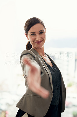 Buy stock photo Portrait of a young businesswoman extending her arm for a handshake