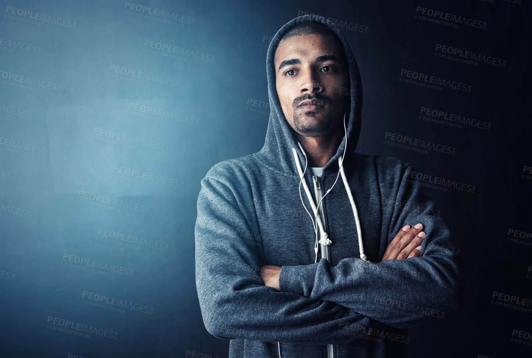 Buy stock photo Man, arms crossed and hoodie in studio for training with thinking, workout and earphones by dark background. Person, music and mock up space to start exercise, pride and fitness routine for health