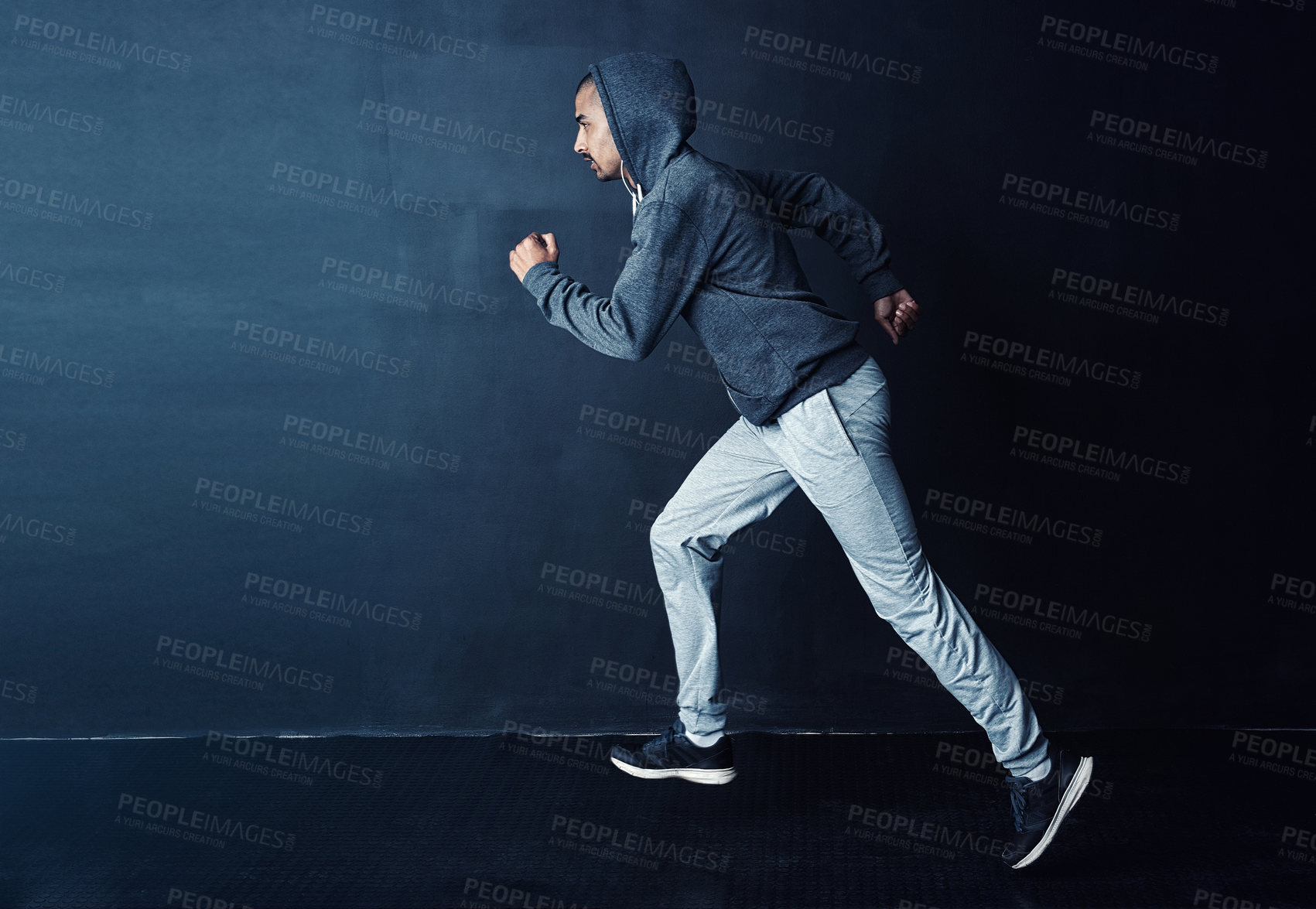 Buy stock photo Studio shot of a sporty young man running against a dark background