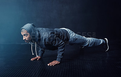 Buy stock photo Fitness, man and push up at gym wall for exercise, training and strong arm muscle development. Person, intense workout and mindset in dark for wellness, endurance and challenge lifting body weight