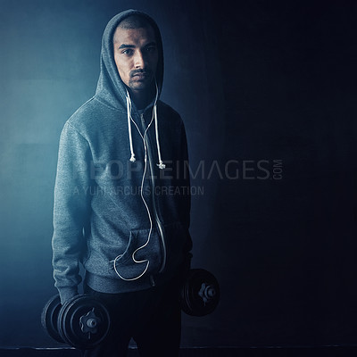 Buy stock photo Studio portrait of a young man working out against a dark background