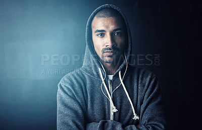 Buy stock photo Man, arms crossed and earphones in studio for workout with portrait, training and hoodie by dark background. Person, audio and streaming music to start exercise, pride and fitness routine in Mexico