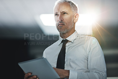 Buy stock photo Shot of a businessman standing in an office using a digital tablet