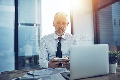Buy stock photo Shot of a businessman using wireless technology in his office