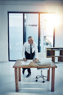 Buy stock photo Shot of a businessman working at his desk in an office