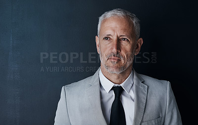 Buy stock photo Studio shot of a thoughtful mature businessman against a dark background