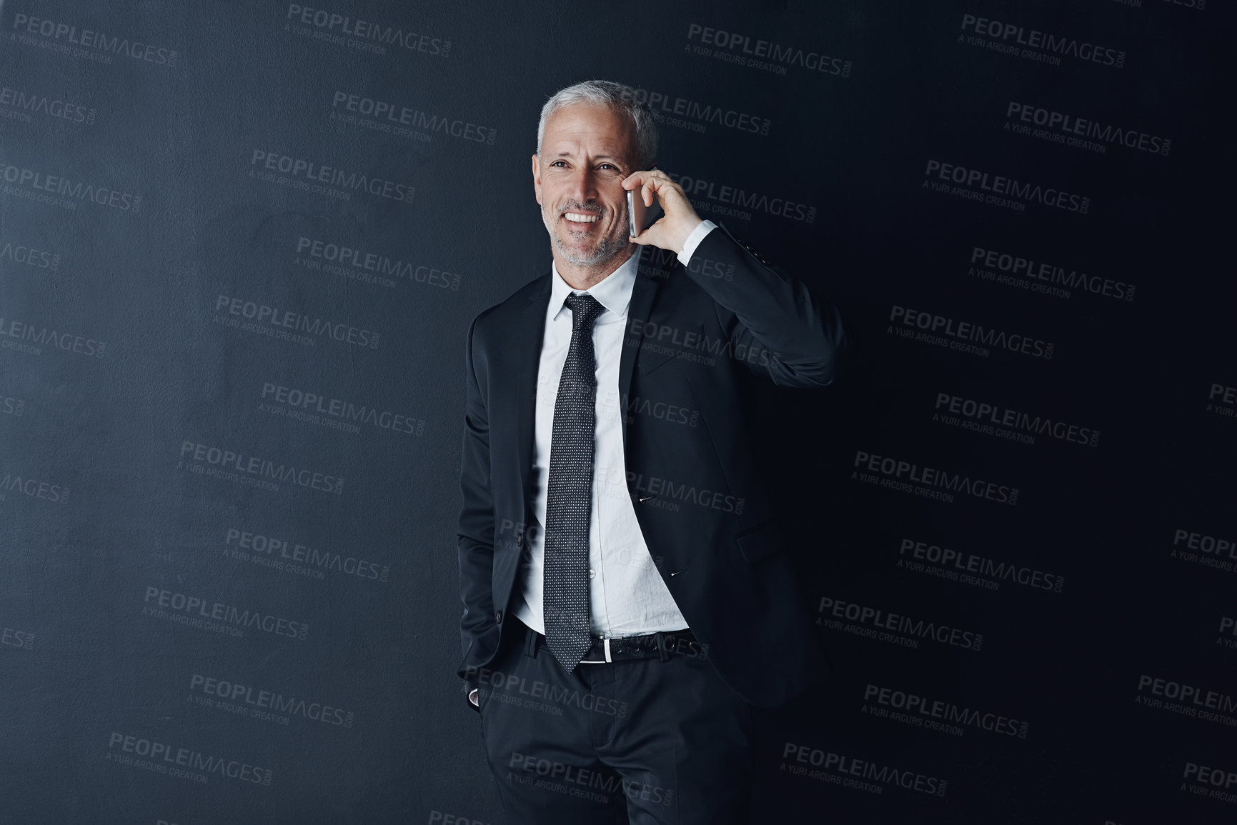 Buy stock photo Phone call, happy and mature businessman in a studio for an online corporate or legal consultation. Smile, technology and professional senior male lawyer on a mobile conversation by black background.
