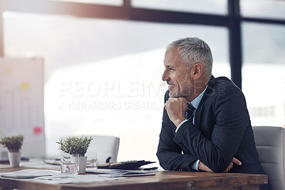Buy stock photo Shot of a mature businessman sitting at his desk in the office