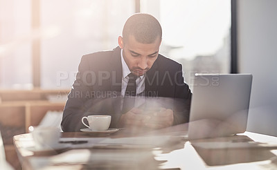 Buy stock photo Shot of a young businessman using his smartphone at work