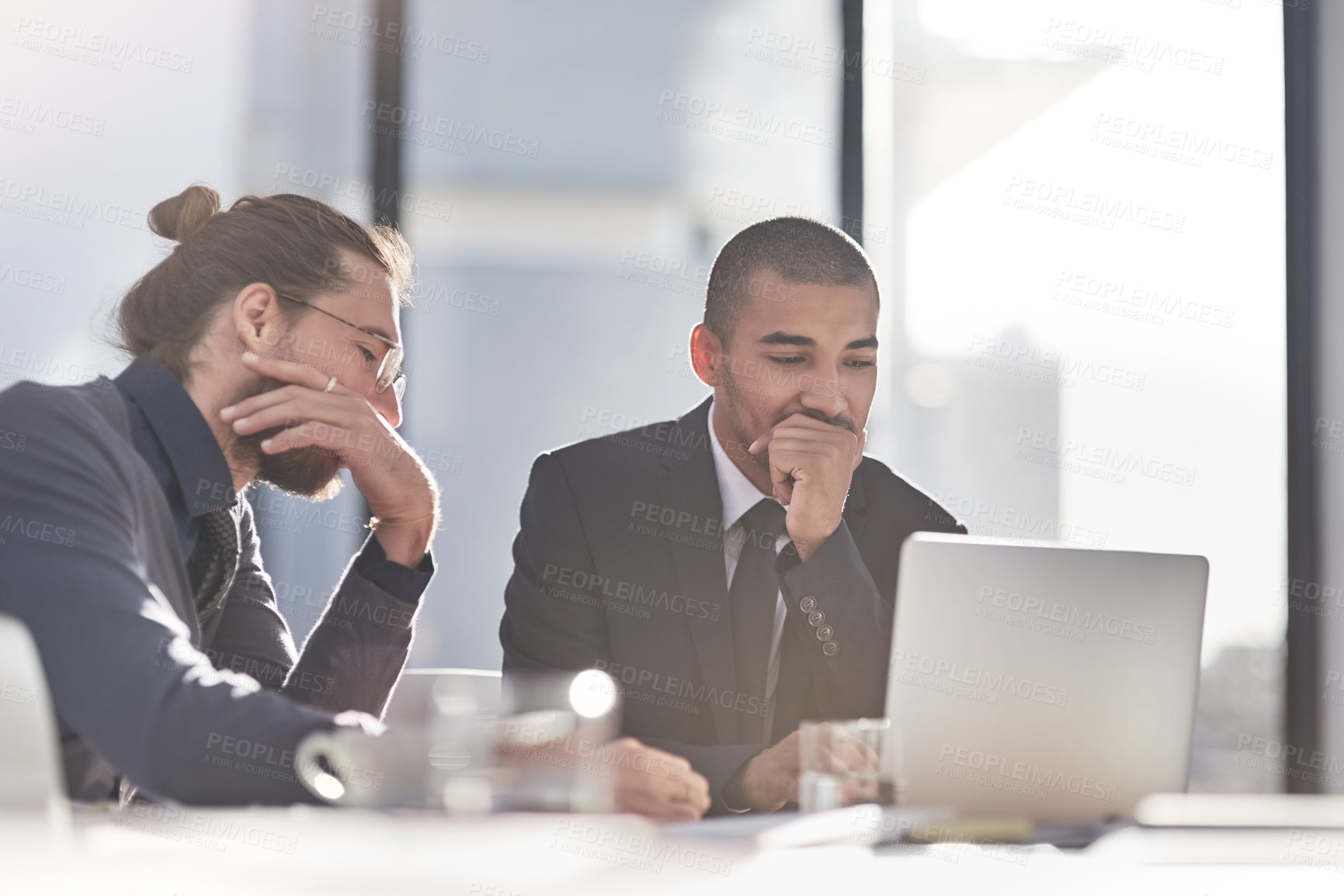 Buy stock photo Shot of two young businessmen using a laptop together at work