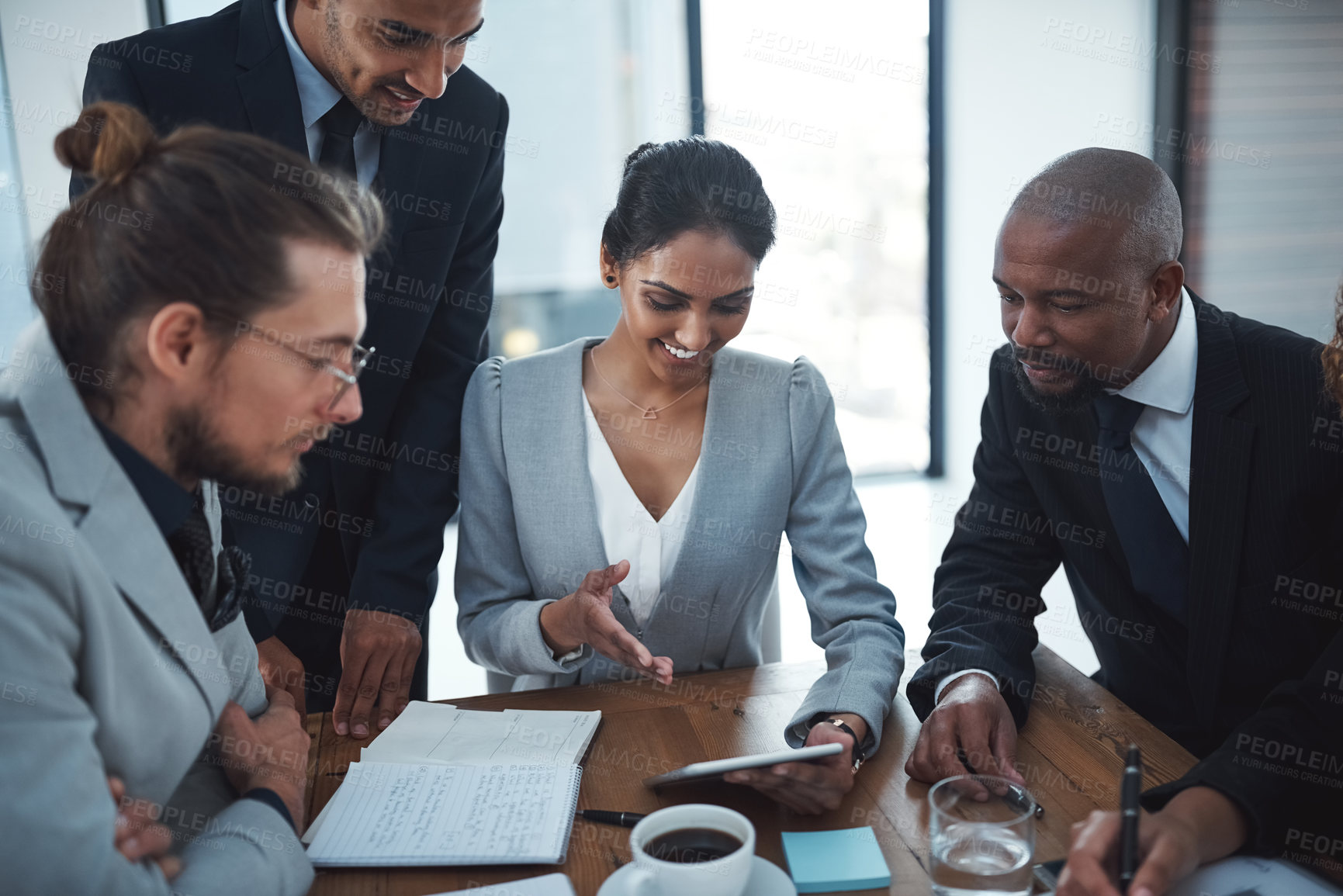 Buy stock photo Shot of a group of businesspeople discussing something on a digital tablet