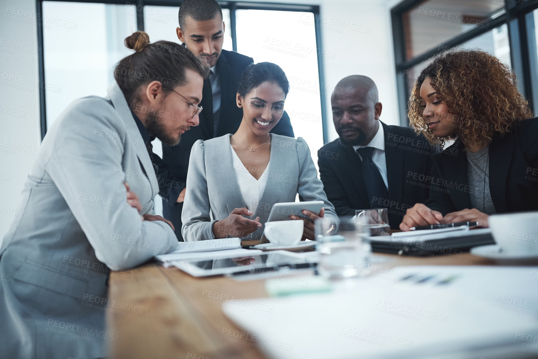 Buy stock photo Shot of a group of businesspeople discussing something on a digital tablet