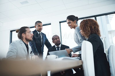 Buy stock photo Shot of a group of businesspeople discussing something on a laptop