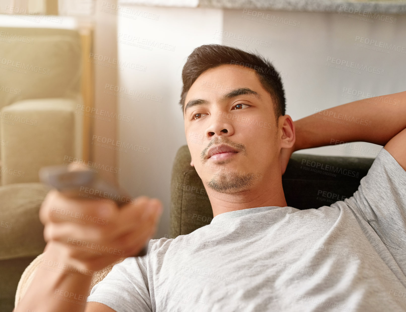 Buy stock photo Movie, relax and man with remote of sofa for streaming service, subscription and watching tv at home. Calm, and male person with control in living room for series, entertainment and broadcast of news