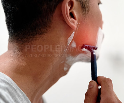 Buy stock photo Shot of a young man at home getting razor burn on his face from shaving with a disposable razor