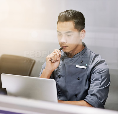 Buy stock photo Cropped shot of a thoughtful young man working on his laptop