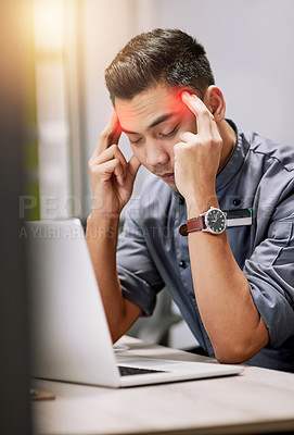 Buy stock photo Shot of a young man suffering with a headache while working on his laptop