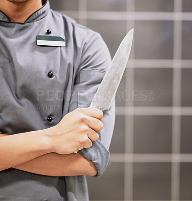 Buy stock photo Cropped shot of an unrecognizable chef holding a knife in his kitchen