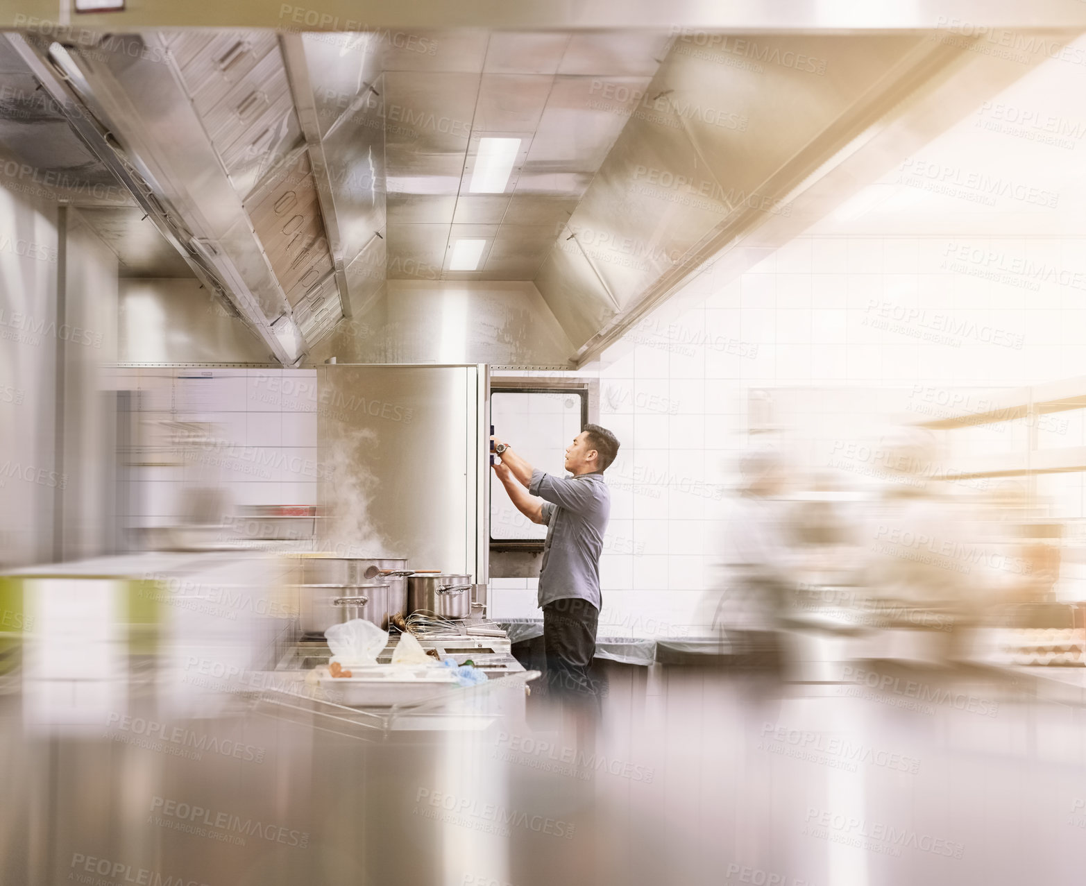 Buy stock photo Cropped shot of a young male chef cooking in his kitchen