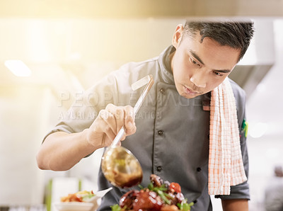 Buy stock photo Cropped shot of a young male chef cooking in his kitchen