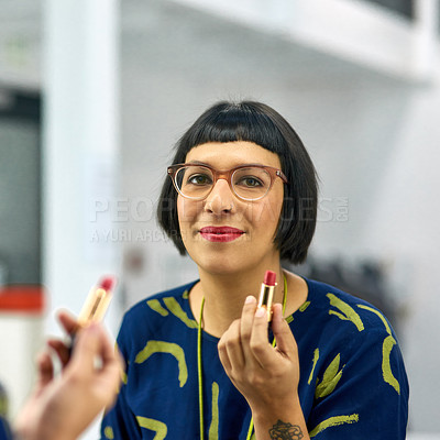 Buy stock photo Portrait of a stylish young woman applying red lipstick in a mirror