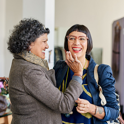 Buy stock photo Shot of a mother and her adult daughter laughing while out shopping together