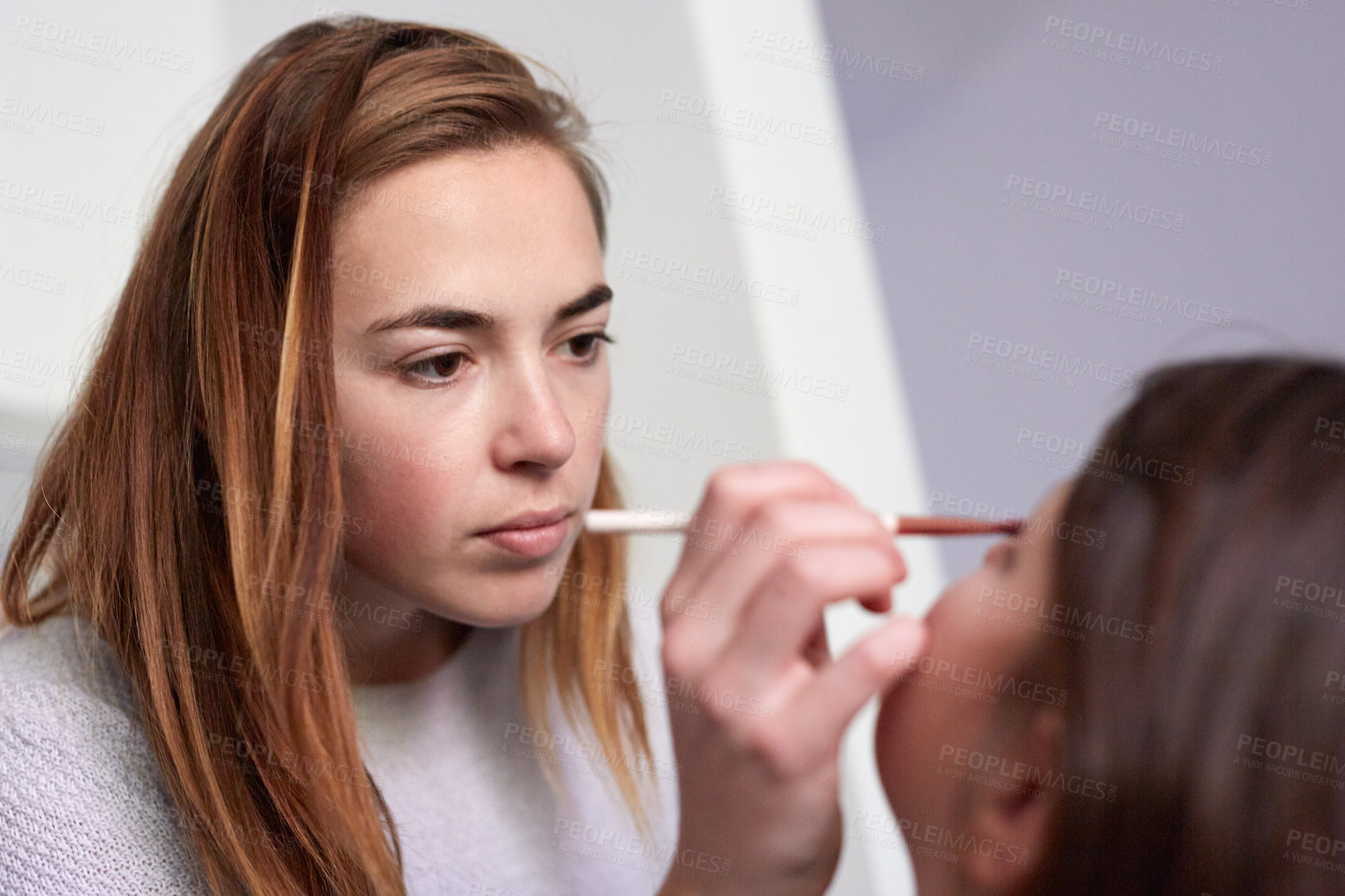 Buy stock photo Shot of a mother applying makeup to her little girl at home