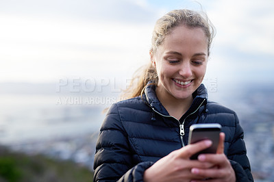 Buy stock photo Cropped shot of an attractive young woman texting on a cellphone outside