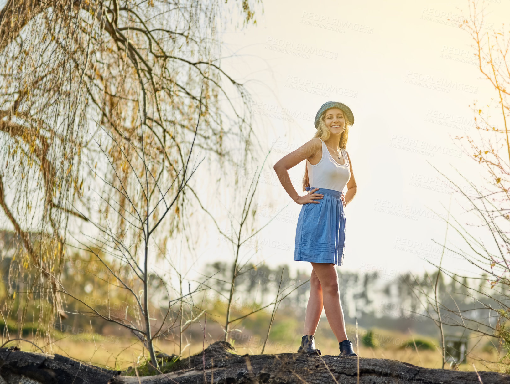 Buy stock photo Happy, woman and tree stump in nature for peace, wellness and rest on vacation or holiday. Excited, person and smile for environment to relax on spring break with walk in countryside and fields