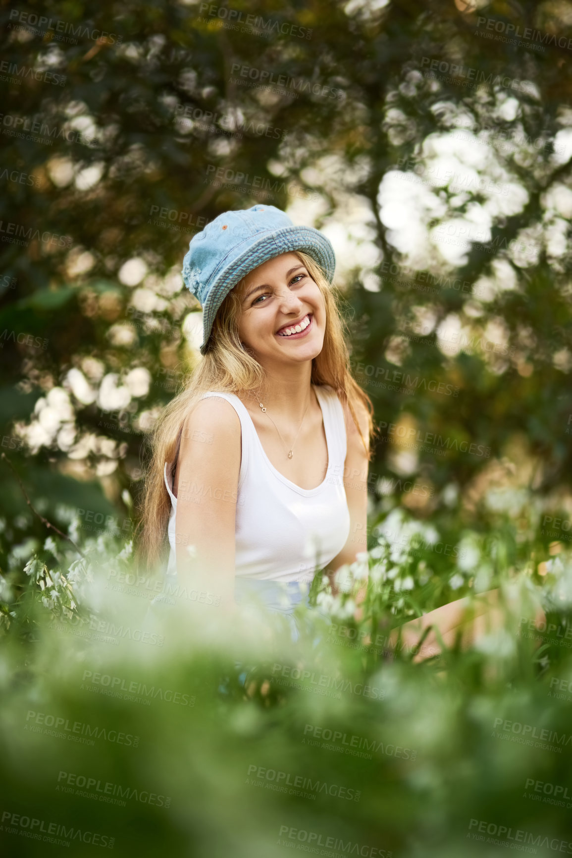 Buy stock photo Female person, smile and portrait with flowers in field, nature and outdoors in countryside for happiness. Woman, hat and summer with dress on ground for relax, zen or calm in grassland for wellness