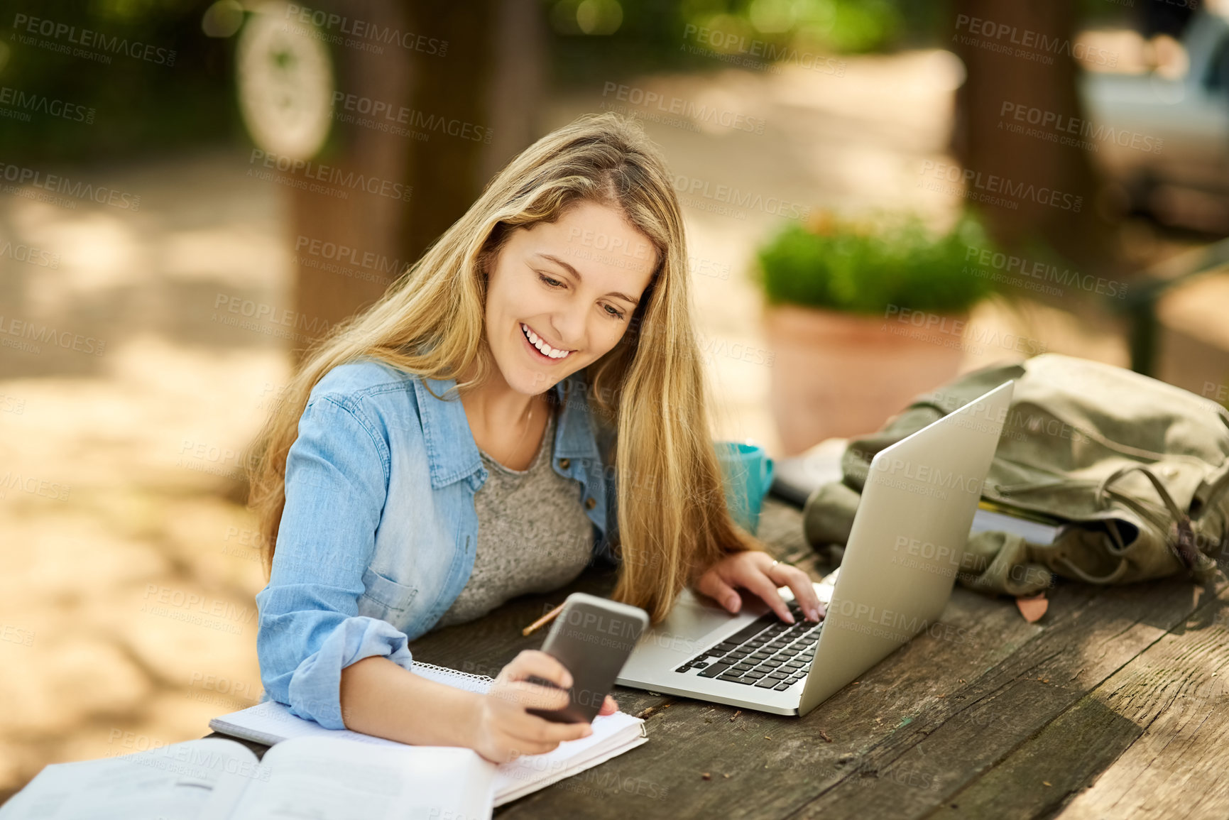 Buy stock photo Woman, student and phone in park with laptop, books and happy for notification, scholarship or test results. Girl, e learning and education with smartphone, computer and smile for university project