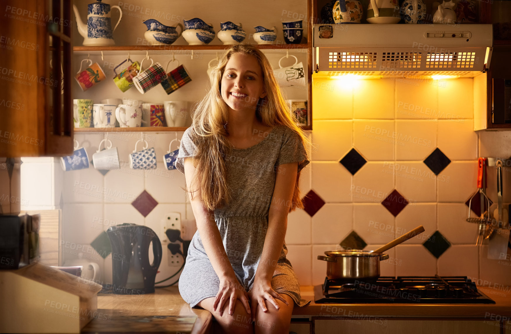 Buy stock photo Portrait of an attractive young woman sitting in her kitchen