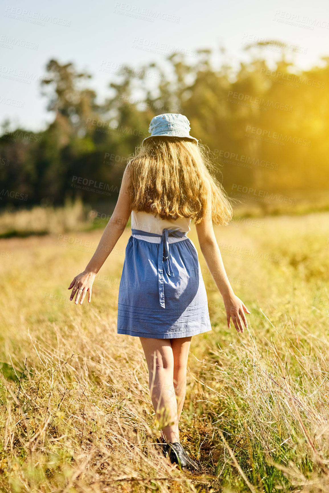 Buy stock photo Gen z, girl and walking in nature for freedom, travel and adventure in countryside for spring. Woman, journey and sunshine in natural environment with flowers, leaves and vacation or holiday outdoor 