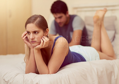 Buy stock photo Shot of an unhappy young woman lying on the bed after having a fight with her boyfriend