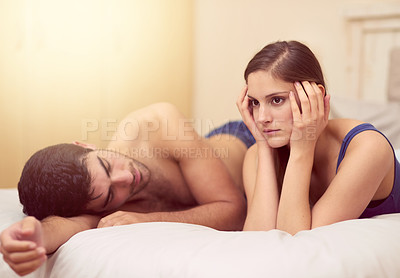 Buy stock photo Shot of an unhappy young woman lying on the bed after having a fight with her boyfriend