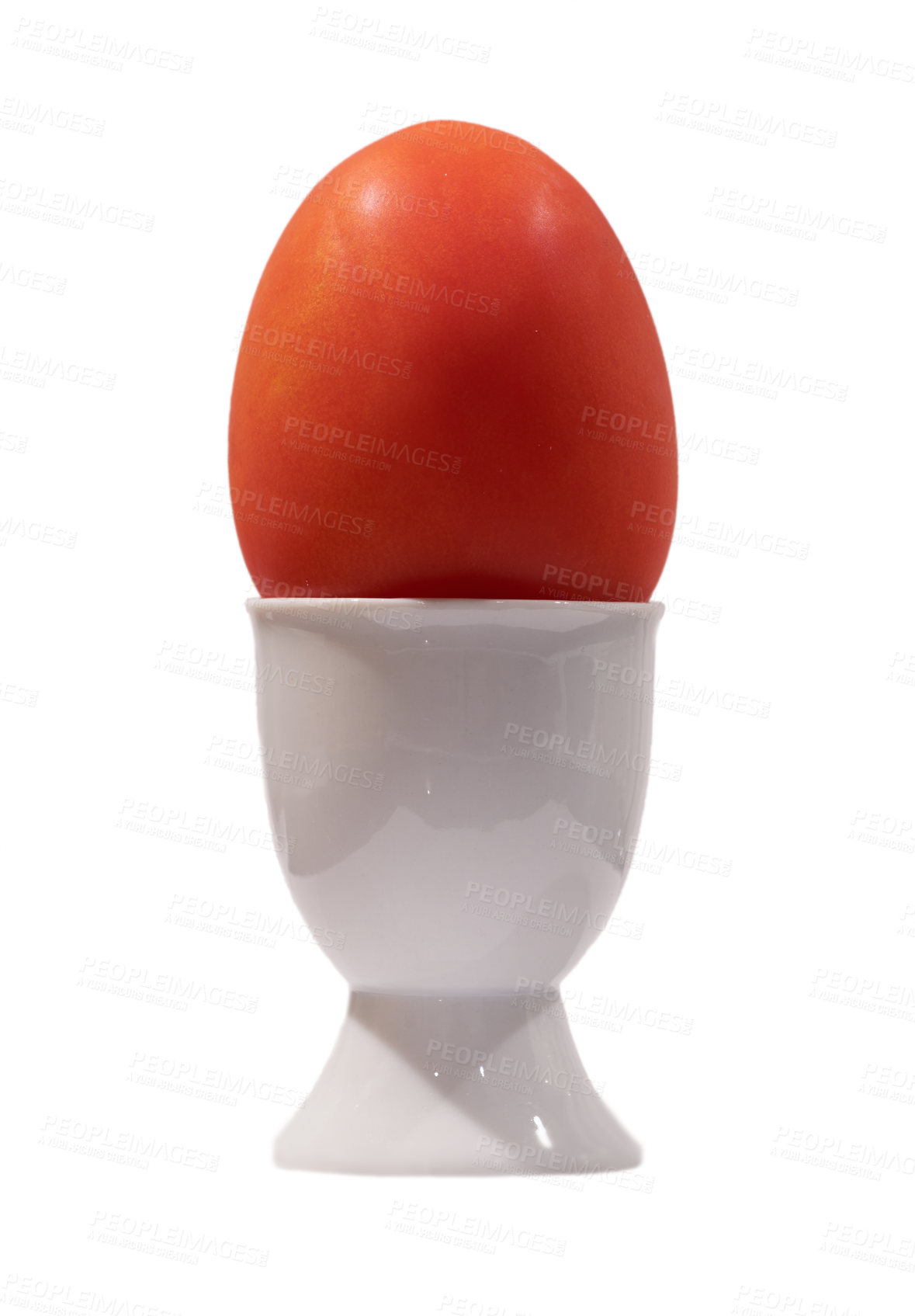 Buy stock photo A photo of healthy organic Tomato is placed vertically isolated on a white background. The tomato is kept in an off-white ceramic egg cup. Close-up shot of a red fresh tomato on white background.