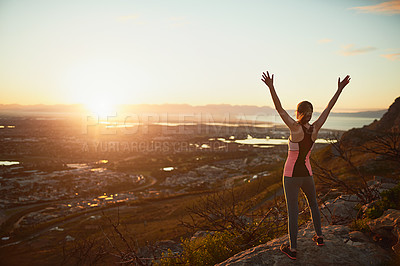 Buy stock photo Rearview shot of a sporty young woman standing outdoors with her arms outstretched