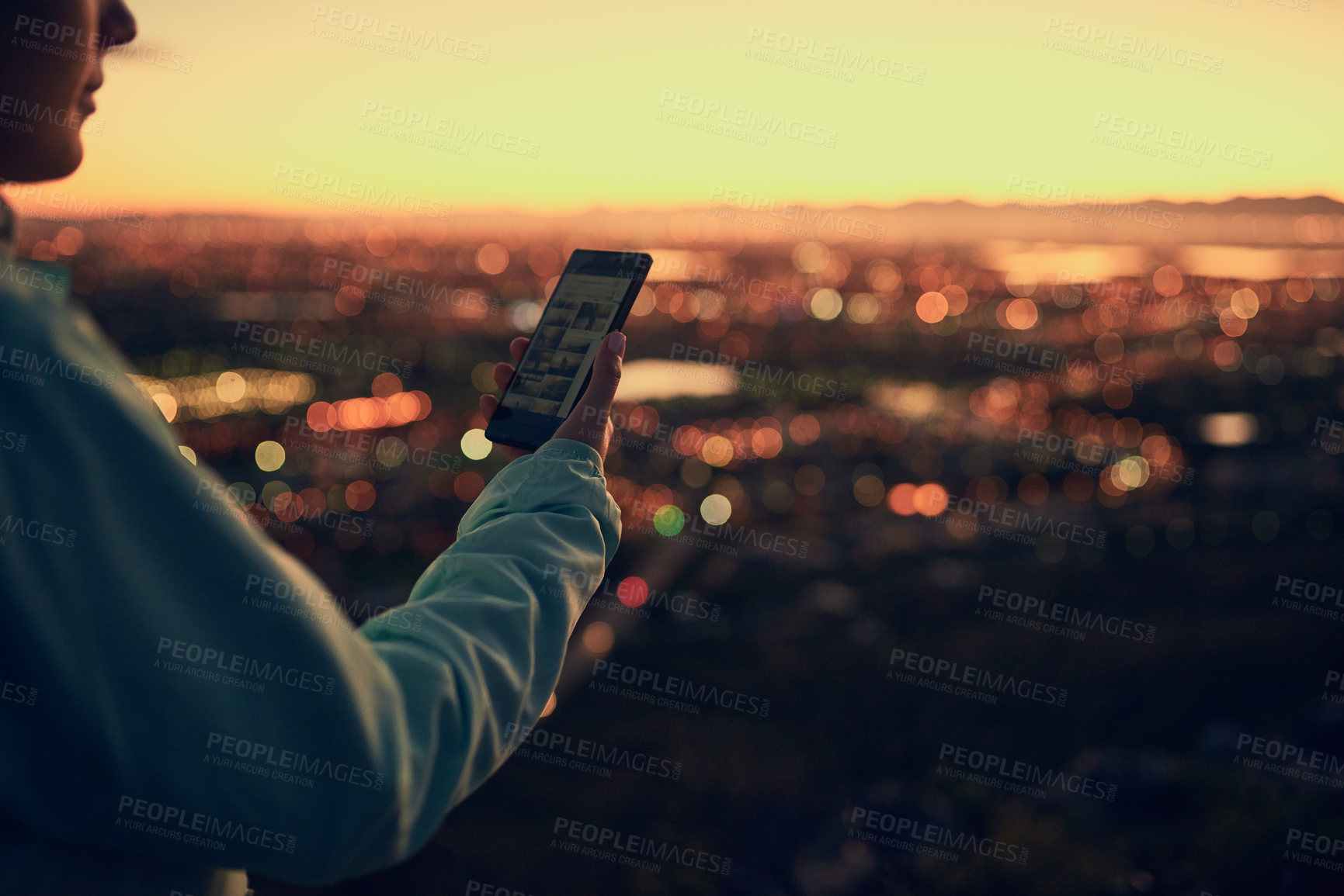 Buy stock photo Shot of an unrecognizable woman sending a text message while standing on a lookout point